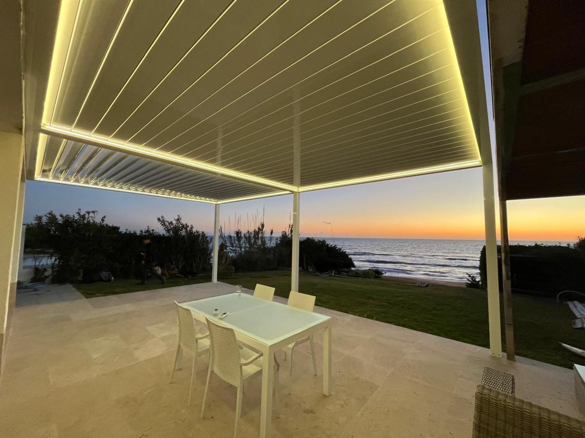 Interior pérgola HIBRA HO450 con LED encendido y vistas al mar