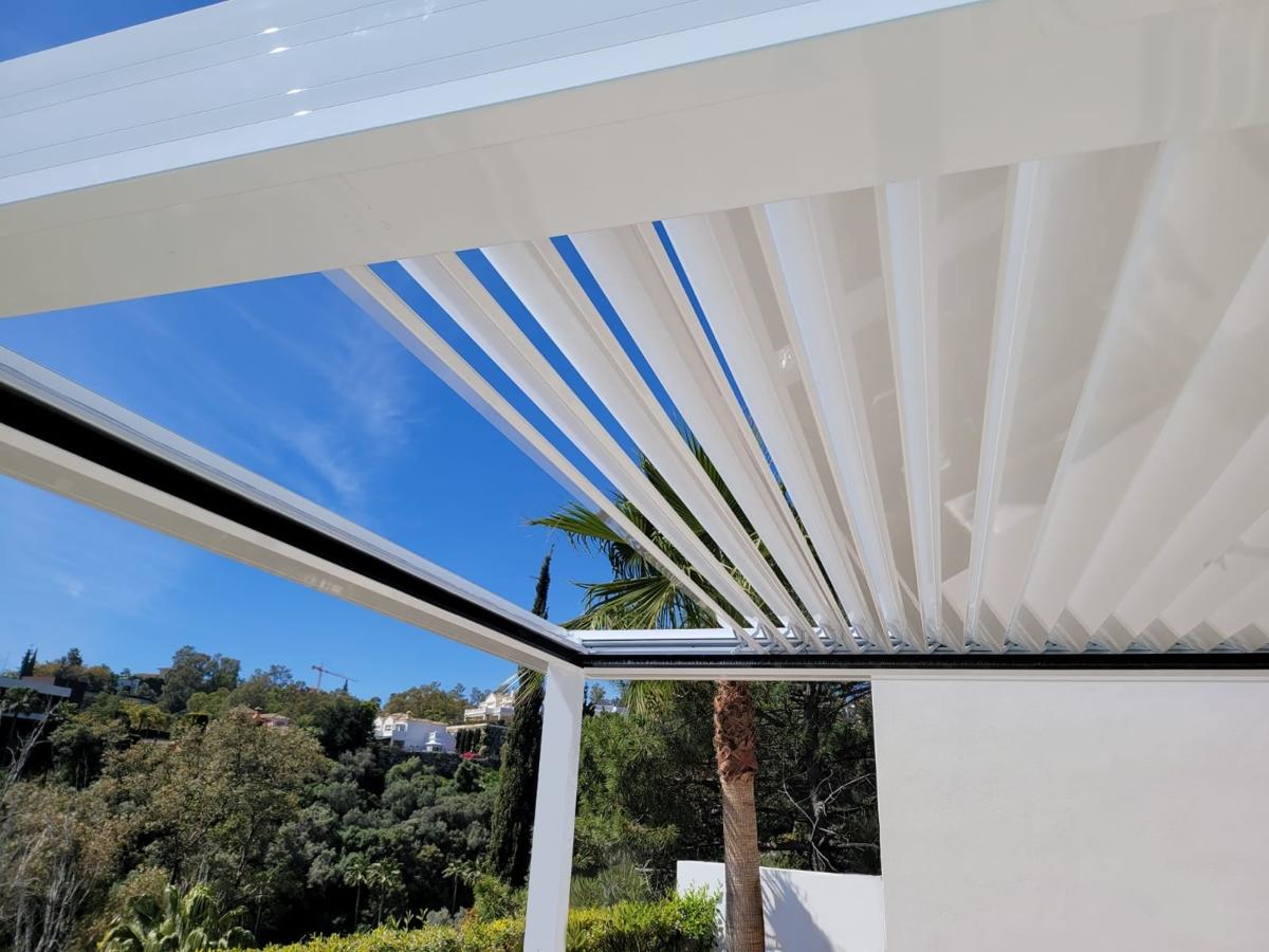 Pérgola bioclimática híbrida HIBRA HOR450 con cortinas de cristal en Fuentebravía