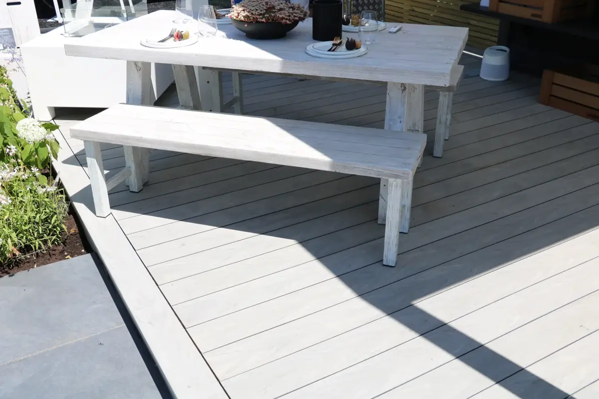 Suelo de madera tecnológica gris en una terraza con comedor exterior