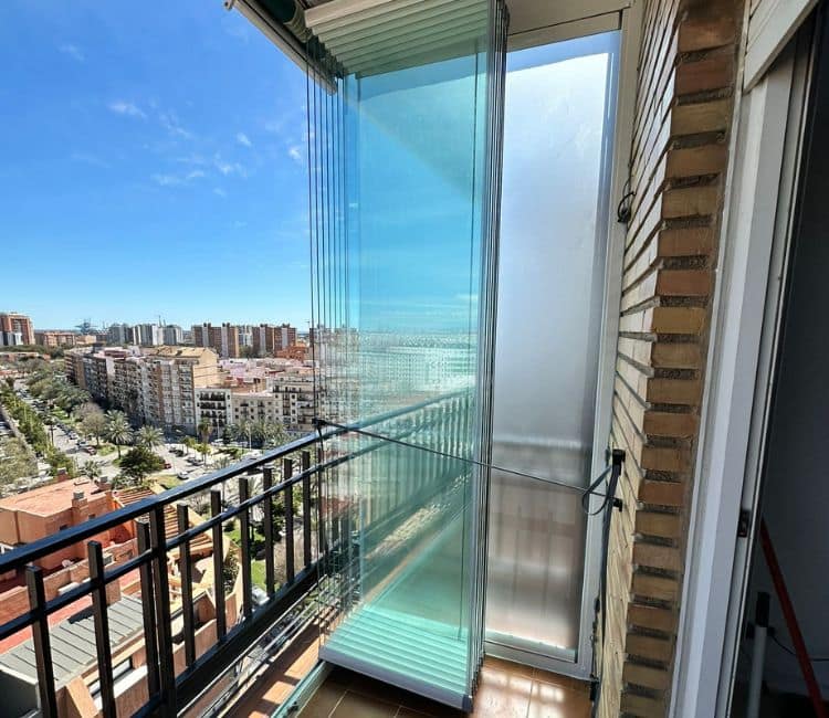 Cortinas de cristal KADO K70 sin guía inferior en balcón con vistas a la ciudad