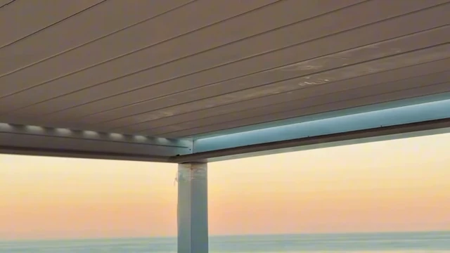 Iluminación integrada en la pérgola frente al mar al atardecer