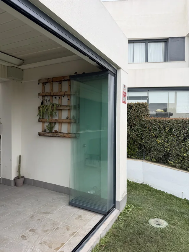 Hojas de cristal recogidas en el lateral derecho del patio
